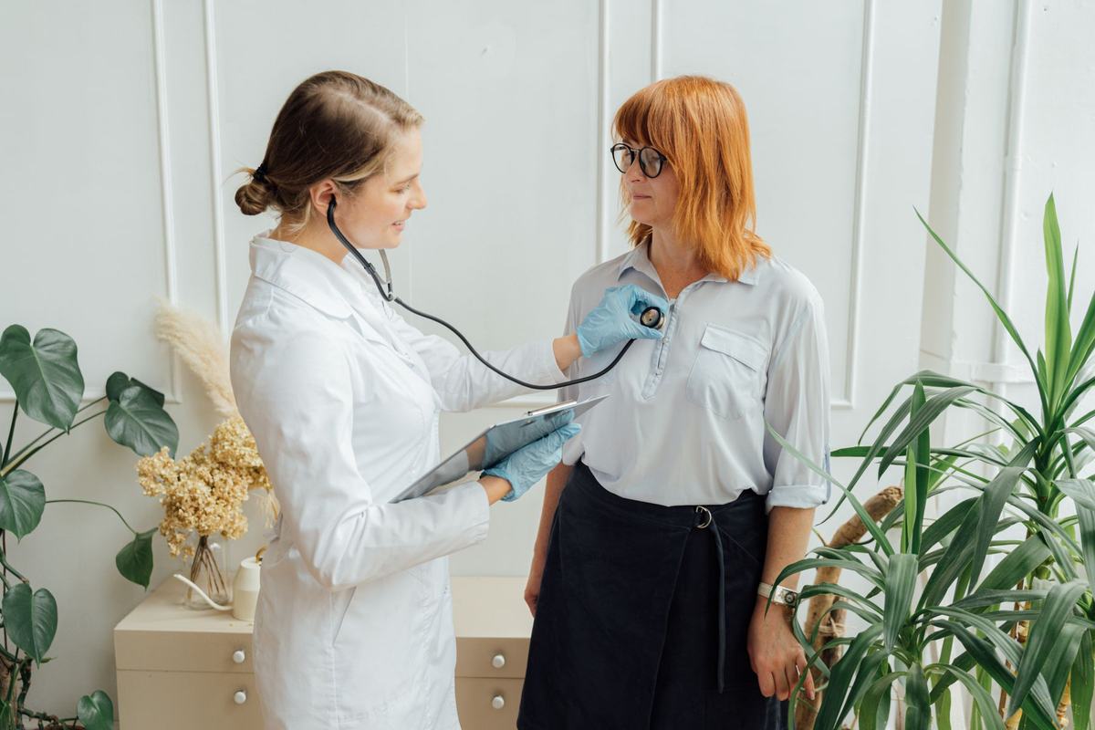 A doctor listens to a patient's heart with a stethoscope