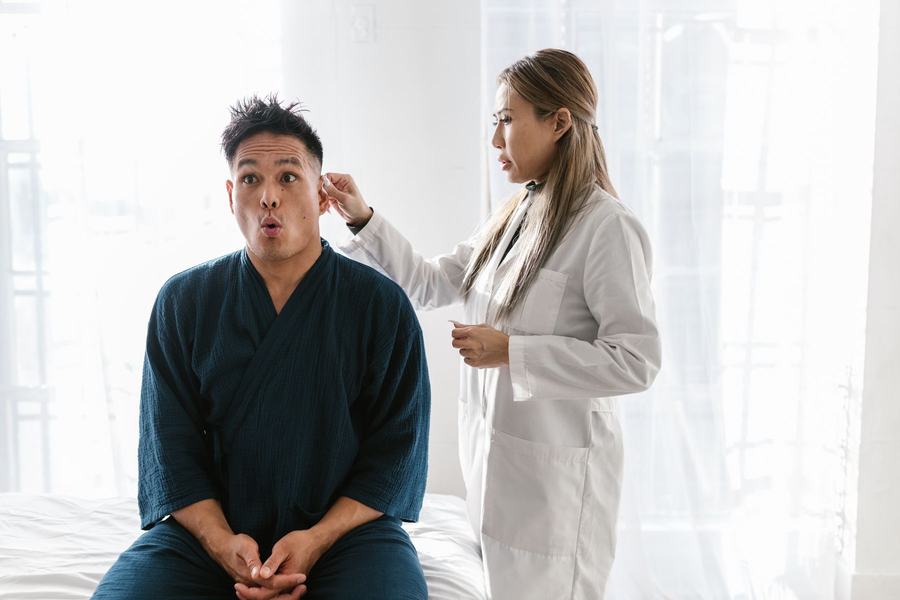 A clinician examines a patient's ear