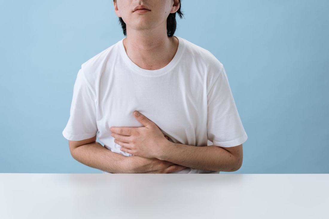 A man holds his stomach in discomfort